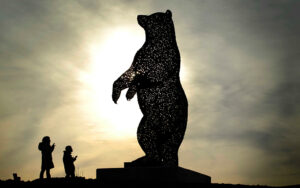 Silhouette of two children facing up to the Dunbar Bear