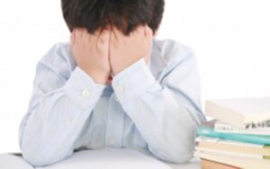 Young boy hiding his face with his hands