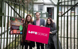 Shona Campbell, Adam McVey and Lynn Bell holding up a love gorgie sign in front of a gate.